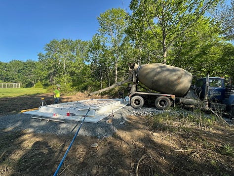 Concrete truck pouring into slab forms