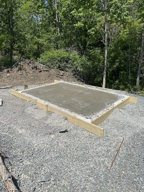 Pouring concrete in the slab forms for both the larger and smaller shed