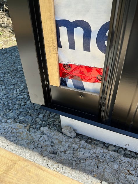 The first pieces of trim and siding being added over the strapping.
